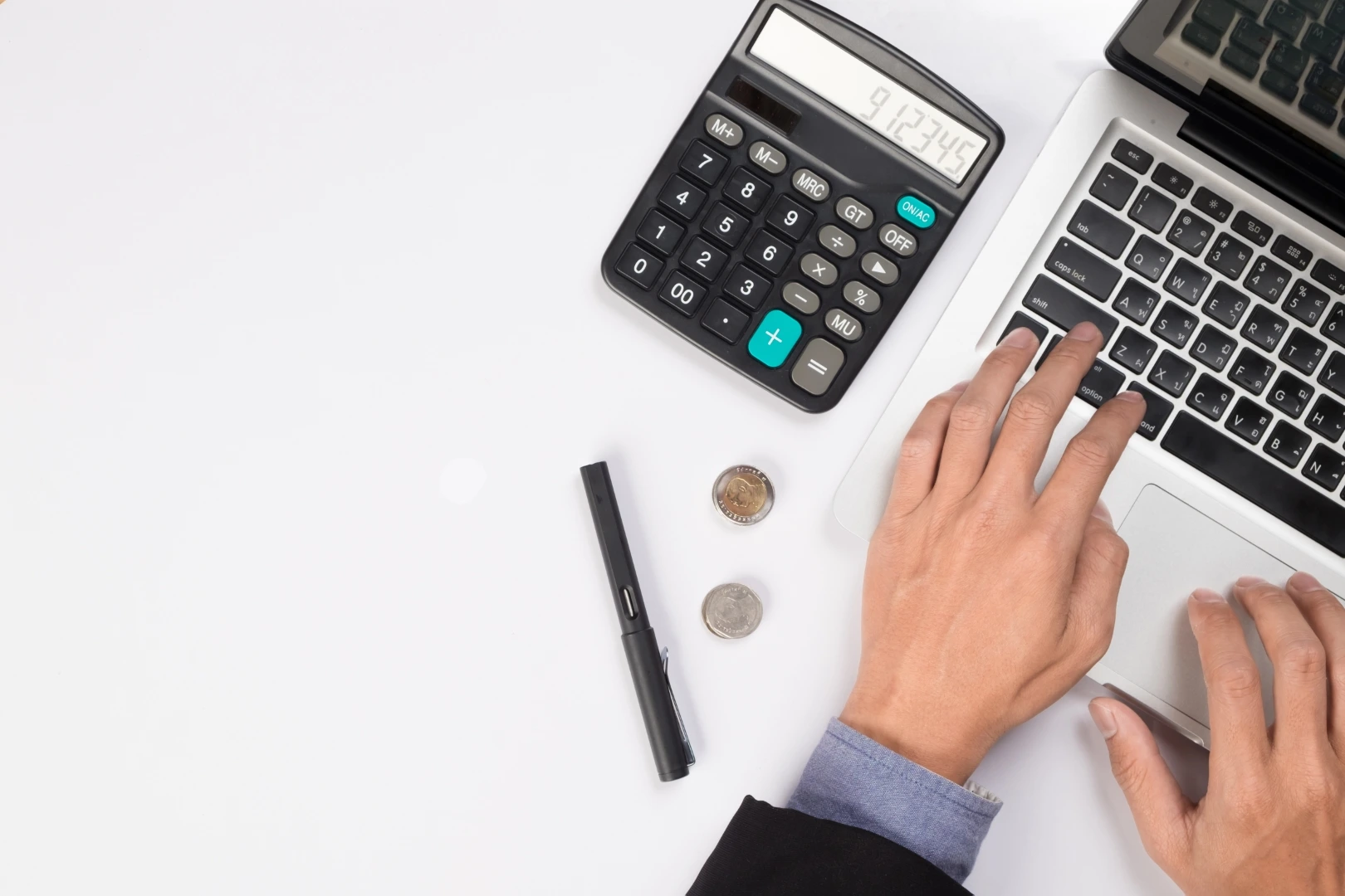 Contadores; una calculadora, una laptop y unas manos de una persona